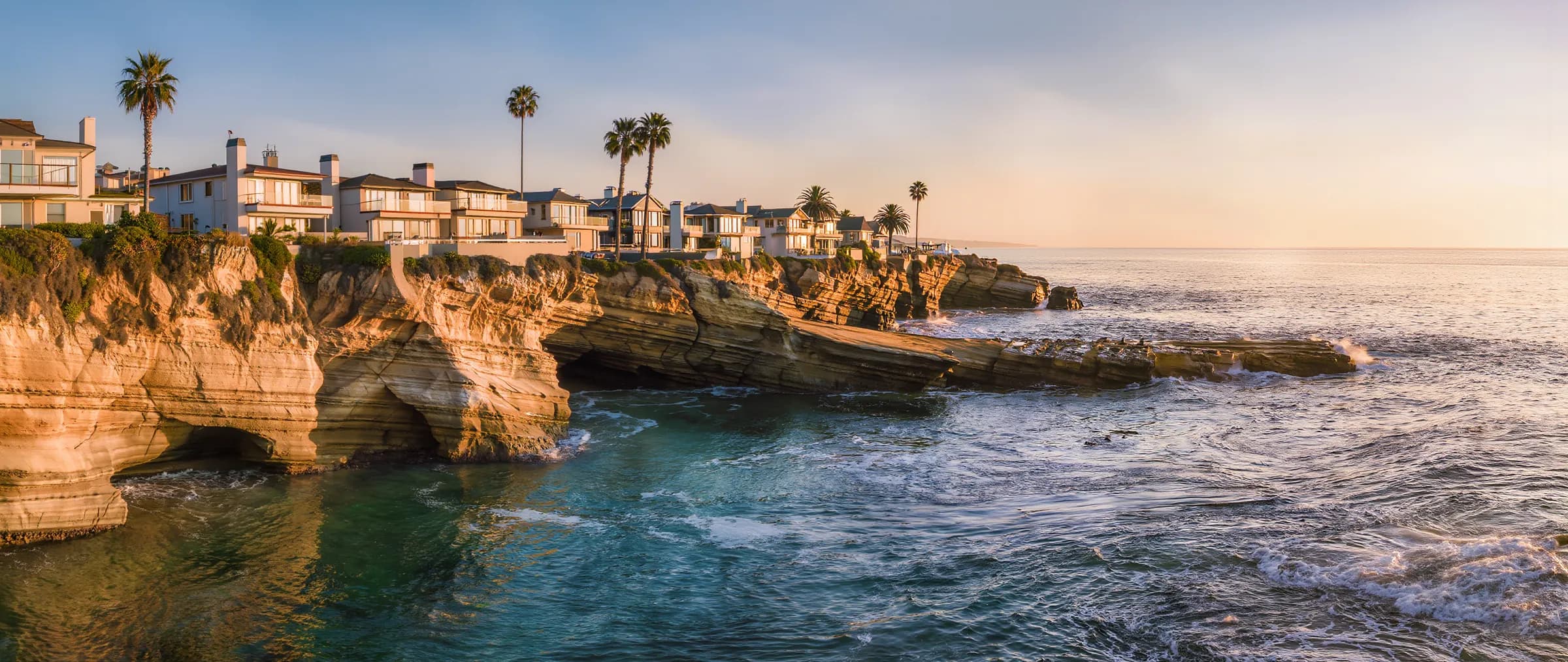 Wide cinematic view of La Jolla's coastal cliffs at golden hour