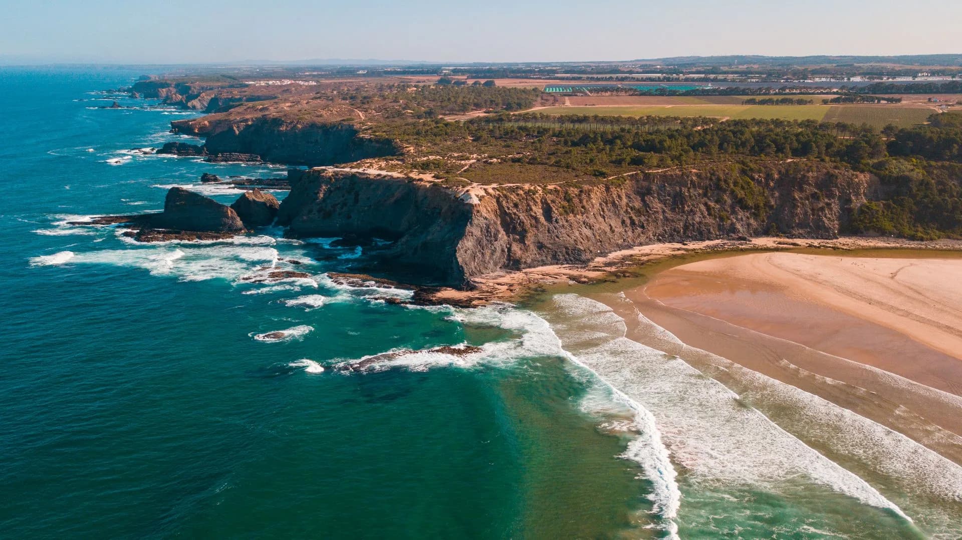 Aerial view of rugged cliffs meeting the ocean along the Southern California coast
